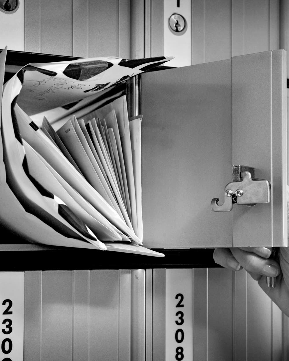 Una mano saca cartas de un apartado de correos