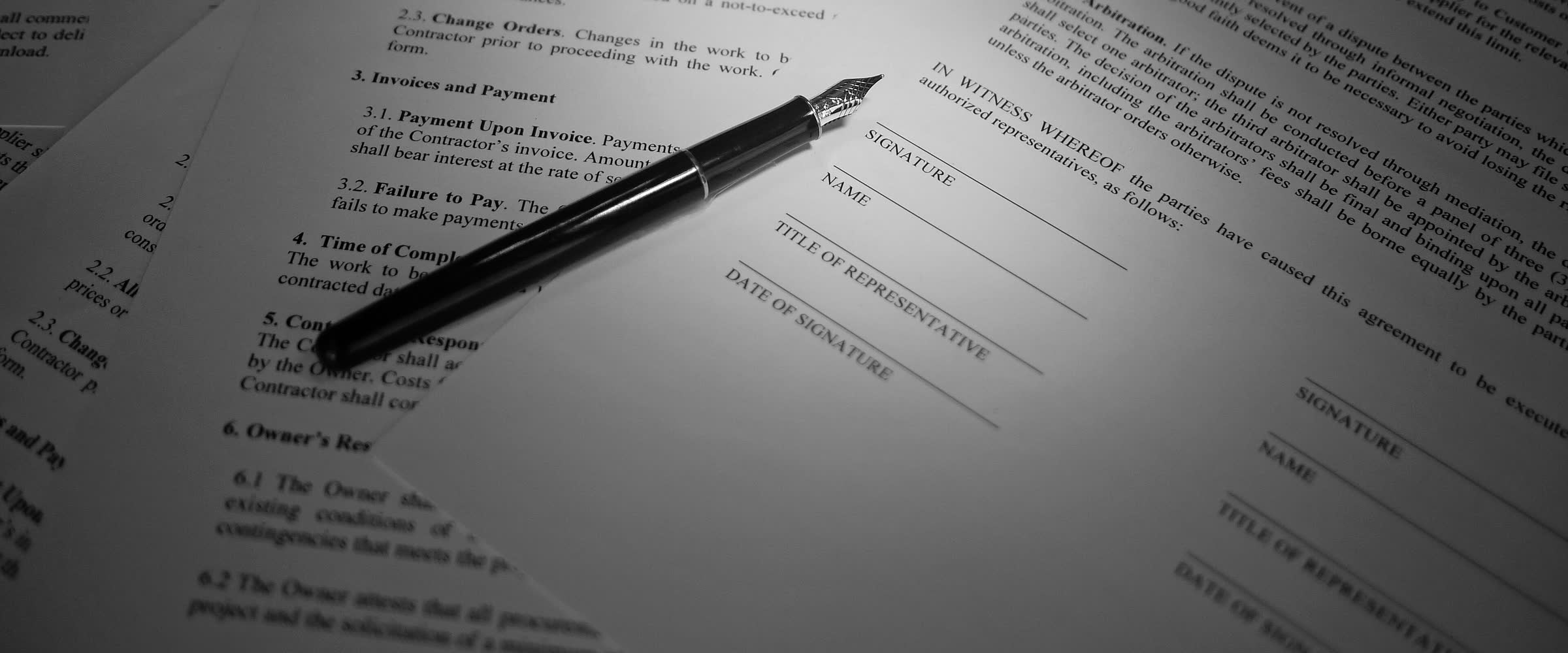 Una pluma sobre las líneas de firma de un contrato